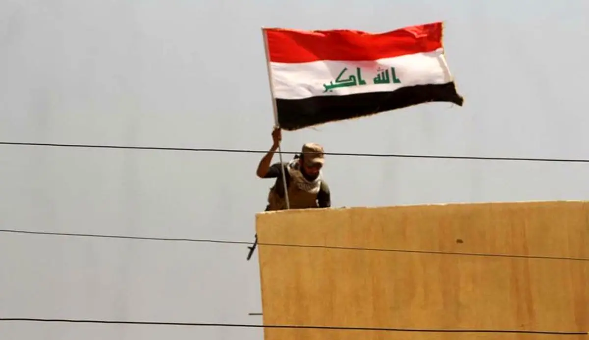 اهتزاز پرچم عراق در یکی از مناطق اطراف موصل