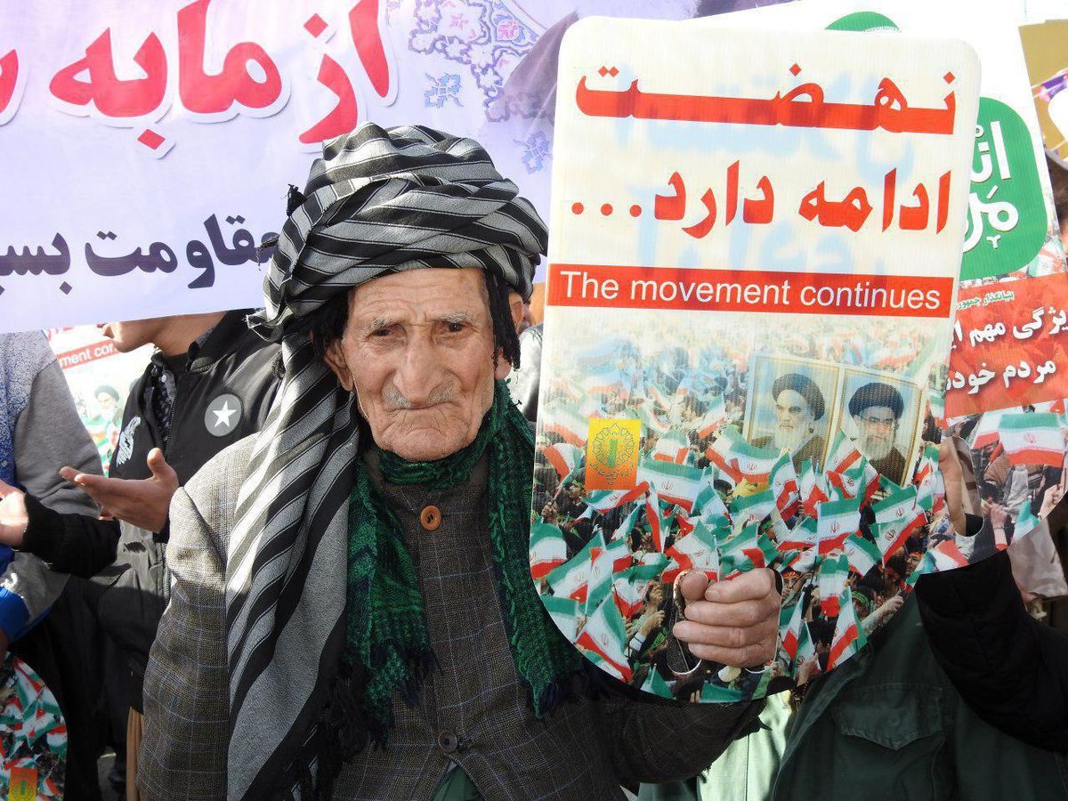 بازتاب رسانه ای از پیرمردی کُرد با پلاکاردِ " نهضت ادامه دارد" در میان راهپیمایی 22 بهمنِ مردم پر شور کردستان +عکس